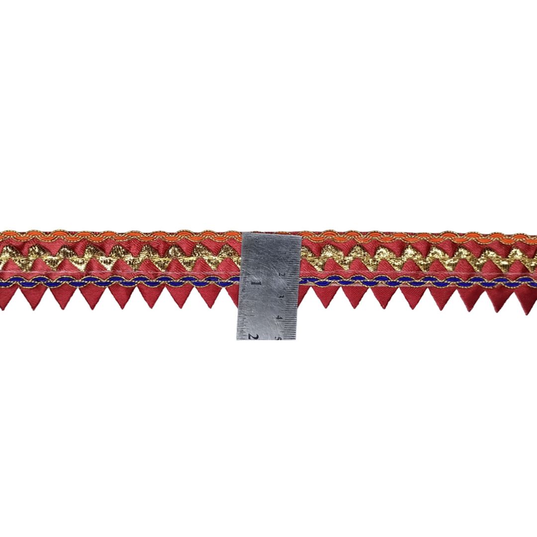 Decorative ribbon with gold and blue pattern next to a ruler on a white background